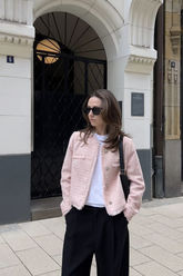 a lady wears a pink tweed jacket with black pants